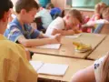 Bambini in classe studiano, un esempio di come le scienze pedagogiche cos'è, osservando l'apprendimento.