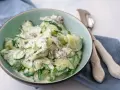 Frischer gurkensalat mit saurer sahne und Dill, garniert mit roten Zwiebeln, in einer Schüssel serviert.