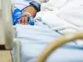 Paciente en cama de hospital con oxímetro en el dedo, indicando la necesidad de permiso por enfermedad.