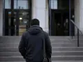 Mężczyzna w ciemnej kurtce wchodzi po schodach. W ręku trzyma torbę, jakby niósł ważny, żelazny list.