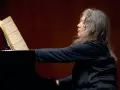 Martha Argerich, pianistka o argentyńskim pochodzeniu, gra na fortepianie, wpatrzona w nuty.