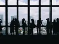 Ludzie w cieniu podziwiają panoramę miasta z okien wieżowca. Niektórzy robią zdjęcia, inni rozmawiają. Te niebezpieczne ujęcia z wysokości zapierają dech w piersiach.