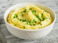 Puszyste, kremowe puree ziemniaczane, posypane świeżą natką pietruszki. Idealny dodatek do obiadu, który pokazuje, jak zrobić puree.