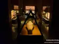 W muzeum archeologicznym w Krakowie dzieci oglądają starożytną mumię w sarkofagu.