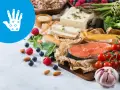 Zdrowa dieta przy łuszczycy: łosoś, warzywa, owoce, orzechy i tofu. Ikona dłoni symbolizuje ulgę.