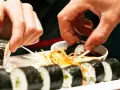 Ręce zanurzają sushi w sosie sojowym. Czy sushi można jeść na drugi dzień? To zależy od świeżości składników i sposobu przechowywania.