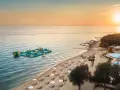 Zachód słońca nad morzem przy plaży z dmuchanym placem zabaw i basenem. Idealne miejsce na wakacje w camping Vrila.