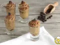 Delizioso spumone al caffè in bicchierini, guarnito con chicchi di caffè e cacao. Perfetto per una pausa golosa.
