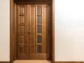 Puertas dobles de madera con paneles y vidrio, ideales para inspirarte sobre como elegir el color de las puertas de interior.