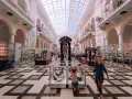 Dzieci zwiedzają muzeum dla dzieci, podziwiając szkielety prehistorycznych zwierząt i wystawy w gablotach.