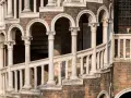 La scala Contarini a Venezia, con i suoi archi e colonne in marmo bianco, si snoda su una struttura in mattoni rossi, un'elegante spirale nel tempo.