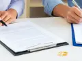Deux mains signent des documents, symbolisant la fin d'une union. Attention au délai pour réclamer une prestation compensatoire.