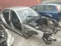 Złomowanie auta: srebrny sedan bez maski i zdemontowanymi częściami, obok niebieski kombi.