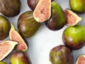 Frische Feigen, teils angeschnitten, zeigen ihr saftiges Inneres. Man fragt sich, wie schmecken feigen wohl? Süß und honigartig.