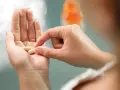 Dłoń trzyma kapsułki, które mogą być lekami do hormonalnej terapii zastępczej.