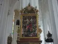 Wnętrze Bazyliki Mariackiej. Centralnie umieszczony, bogato zdobiony obraz przedstawia Matkę Boską z Dzieciątkiem i sceny z życia świętych.