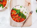 Pyszne czerwone curry z kurczakiem i ryżem, udekorowane świeżą kolendrą. Idealny przepis na obiad.