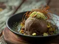 Schokoladeneis-Kugel mit Pistazien und Karamellfäden, ein Hauch von Dubai Eis.