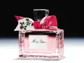 Eleganckie perfumy Miss Dior w różowym flakonie, ozdobione kokardką z motywem róż i napisem "Dites-le avec des fleurs".