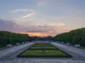 Sonnenuntergang über dem Sowjetischen Ehrenmal in Berlin. Ein beeindruckendes Beispiel für Parks in Berlin, mit symmetrischen Rasenflächen und einer langen Allee.