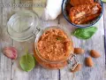 Un vasetto di pesto di pomodori secchi, con mandorle, aglio e basilico, pronto per insaporire i tuoi piatti.
