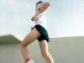 Un atleta corre a tutta velocità, mostrando quanto corre veloce un uomo. Le gambe muscolose si muovono rapidamente, catturando l'essenza della velocità.