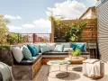 Cómodo rincón de terraza con sofás de obra, cojines turquesas y plantas. Ideas para jardineras exteriores que inspiran relax.