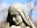 Kamienna twarz kobiety spowita welonem, zamyślona, jakby zastanawiała się, co to jest sumienie.