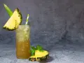 Klasyczny Mai Tai z sokami, ozdobiony kawałkiem ananasa i miętą. Idealny na tropikalny wieczór.