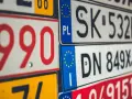 Zbliżenie na stos tablic rejestracyjnych z różnymi kody samochodowe. Widoczne numery to m.in. 990, SK 532HH, DN 849XJ.