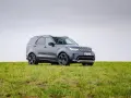 Szary Land Rover Discovery stoi na zielonej łące.