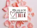 Herzförmige Karte mit dem Spruch "Alles was ihr tut, geschehe in LIEBE. 1.Korinther 16:14", umgeben von zarten rosa Blütenblättern.