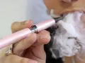 Persona vapea con un dispositivo rosa, liberando vapor. ¿Qué pasa si fumas vaper con nicotina?
