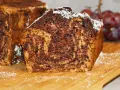Puszysty chlebek bananowy z kakao, oprószony cukrem pudrem, prezentuje się apetycznie na drewnianej desce.