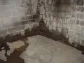 Water stains and pooling on a concrete floor and cinder block walls indicate a serious moisture problem. Learn how to get rid of moisture in basement effectively.