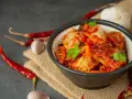 Miseczka z kimchi, obok suszone papryczki chili i czosnek.