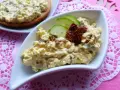 Pyszna pasta jajeczna z suszonymi pomidorami, ozdobiona plasterkami ogórka i pomidorów. Idealna na kanapki.