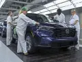 Pracownicy w fabryce Hondy z Japonii kontrolują nowy, ciemnoniebieski SUV.