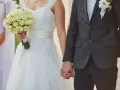 Para młoda trzyma się za ręce. Panna młoda ma bukiet białych róż. Zastanawiasz się, ile świadek daje na wesele?