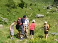 Famille en randonnée facile dans les Pyrénées, profitant d'un paysage verdoyant et rocheux.