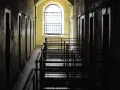 Korytarz więzienny z celami i kratami. Czekanie na decyzję sądu, po jakim czasie sąd wydaje nakaz doprowadzenia do zakładu karnego, może być długie.