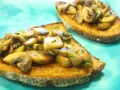 Bruschetta z pieczarkami, podana na chrupiącym pieczywie, kusi aromatem i apetycznym wyglądem. Idealna na szybką przekąskę.