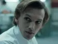Henry Creel, znany jako Vecna z 001 stranger things, w białej koszuli, patrzy z uwagą.
