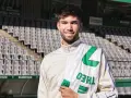 Théo Zidane sonríe con una bufanda del equipo en el estadio.
