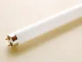 Tubo fluorescente con dos pines dorados, listo para cambiar por uno LED y ahorrar energía.