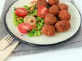 Falafel kontra kotlety sojowe: chrupiące kulki falafela i soczyste pomidorki z edamame na talerzu.