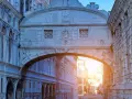 Il Ponte dei Sospiri a Venezia, con la sua architettura barocca e le finestre decorate, si staglia contro il cielo al tramonto, offrendo uno scorcio suggestivo sui canali.