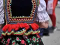 Kolorowy strój ludowy, ozdobiony koralikami i haftem, zapowiada radosne tańce ludowe.