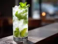 Ett glas med is, mynta och lime, perfekt för ett uppfriskande mojito recept.