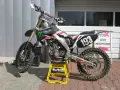 Motocykl crossowy na stojaku. Pytanie: co ile wymieniać filtr powietrza w motocyklu? Regularna konserwacja to klucz do mocy!